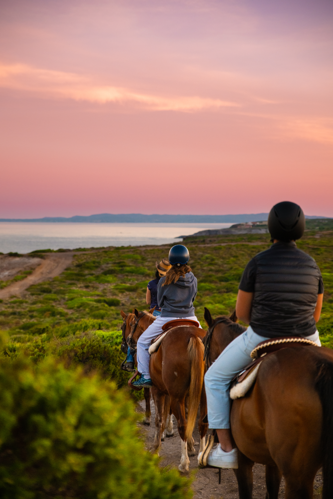 Reiterinnen bei Sonnenaufgang mit Blick auf das Meer von Sant'Antioco